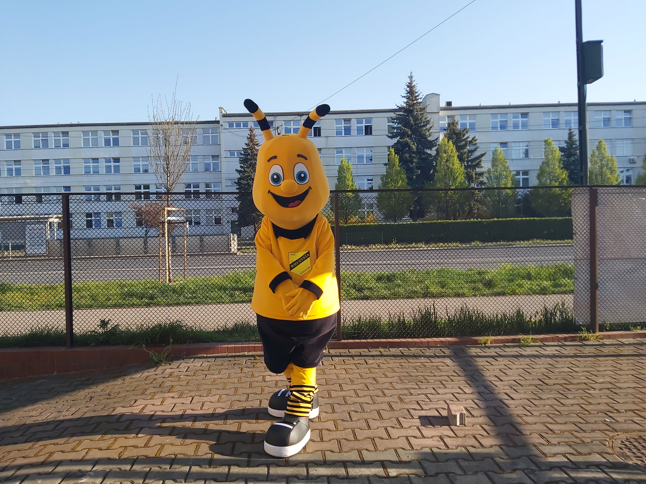 Na fotografii widnieje strój reklamowy w postaci pszczoły pozujący do zdjęcia w siedzibie firmy Elabika